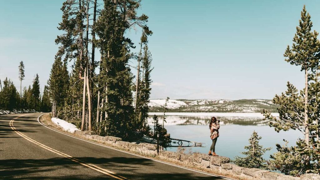 Scenic USA road trip route beside a mountain lake and pine forest