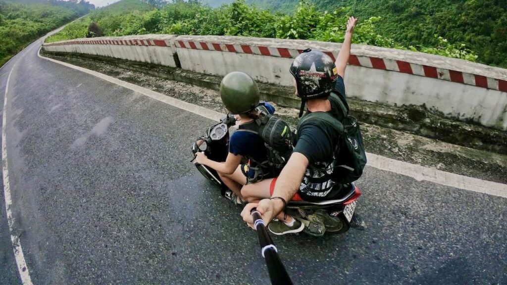 Travelers riding a motorbike in Vietnam and capturing their journey with a selfie stick