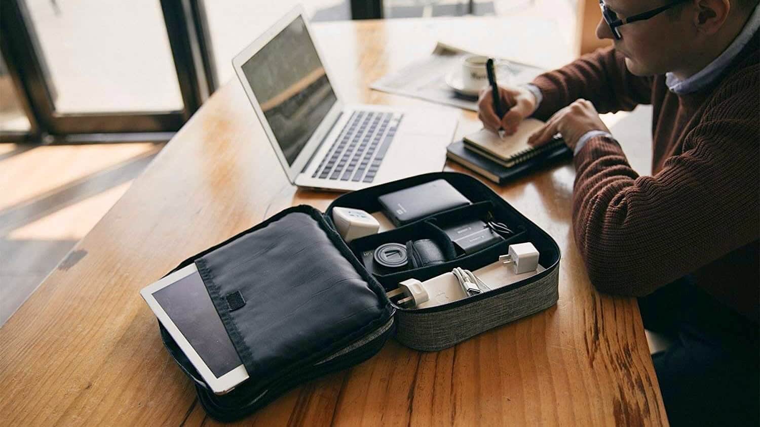 Electronics organizer pouch holding charging cables, power adapters, and other travel gadgets