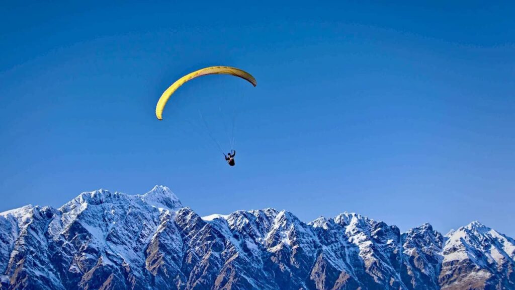 Paraglider flying over the Himalayan mountains in Nepal