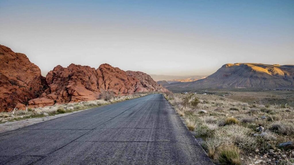Empty road winding through the red sandstone mountains and desert landscape of Red Rock Canyon near Las Vegas