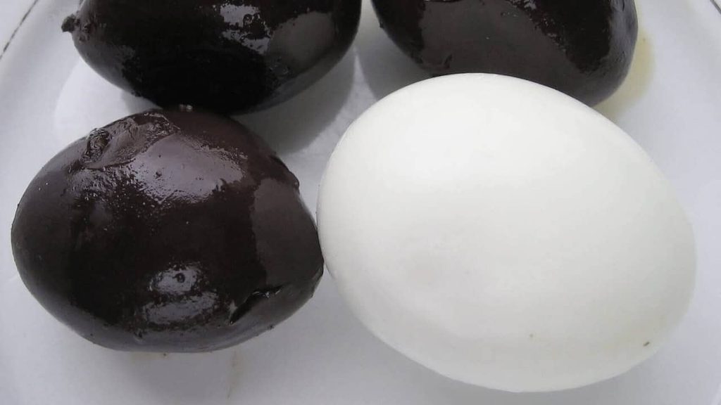 Dark Taiwanese iron eggs on a white plate