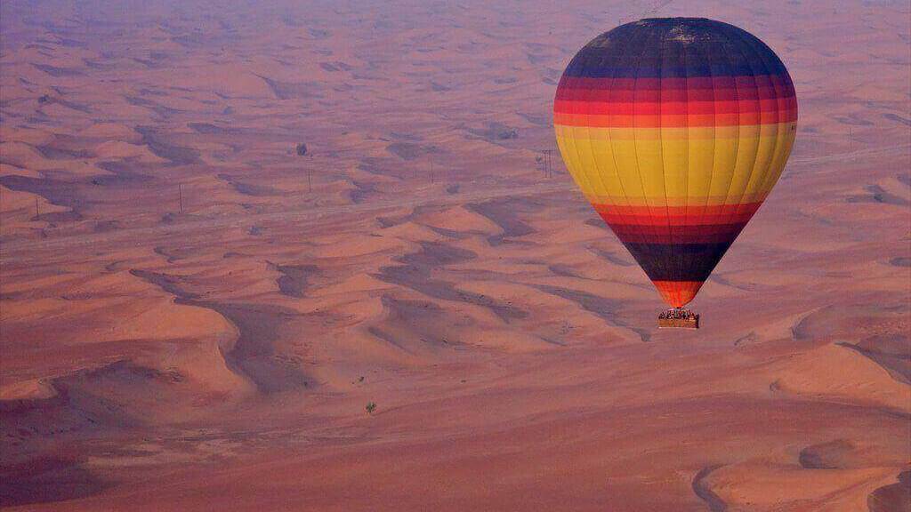 hot air balloon on golden dunes of Arabia
