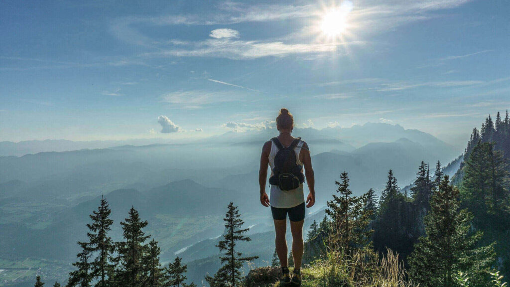 hiker on top of mountain beautiful day sun