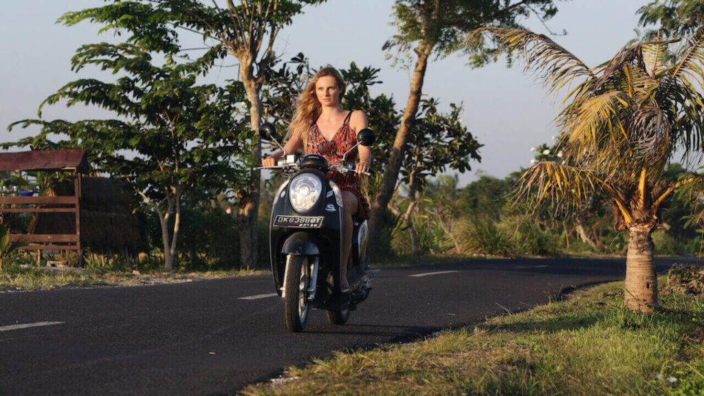 a girl rides scooter to travel to bali cheap