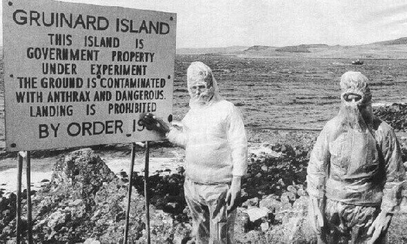 government prohibited sign of people from entering deadly Gruinard island and two man in protective gear