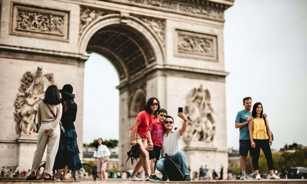 a family of three taking pics at Arc de Triomphe