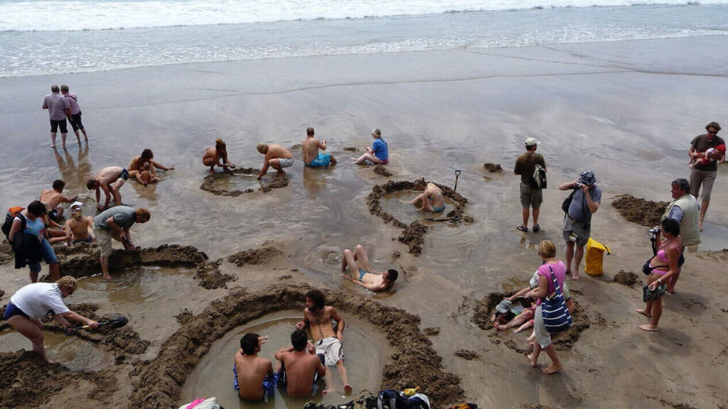People are making their baths on the sand to enjoy the hot springs of Hot Water beach