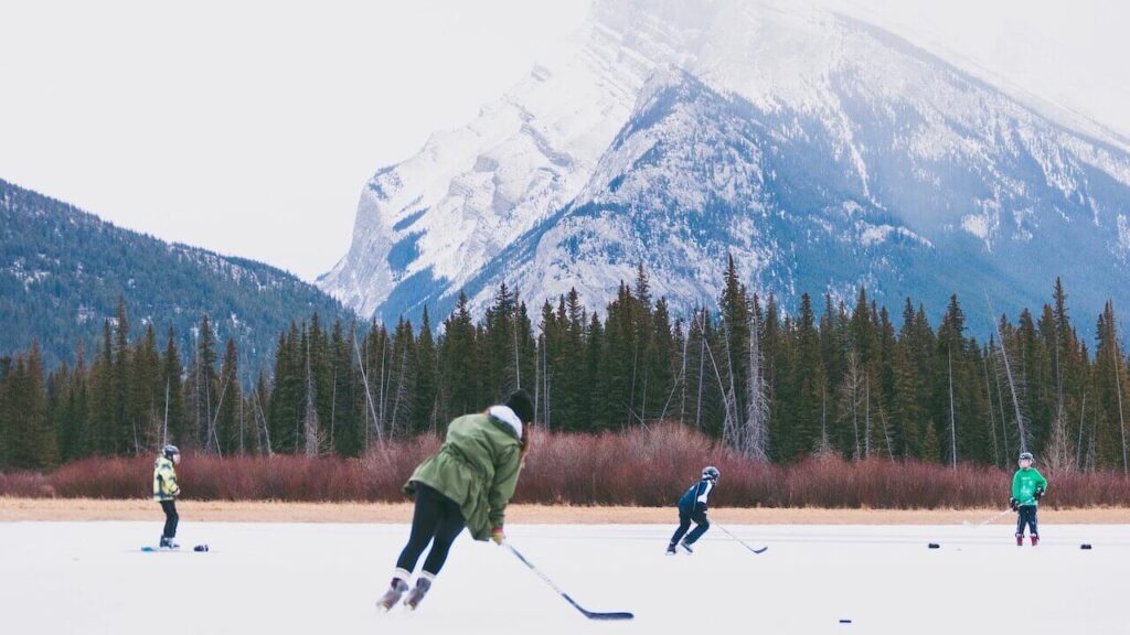 people play hockey on the frozen lakes in the Rocky Mountains in winter