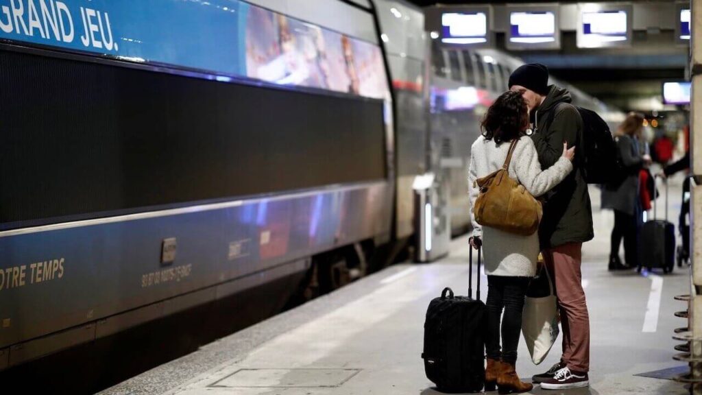 a couple is kissing in a train station in Paris, France