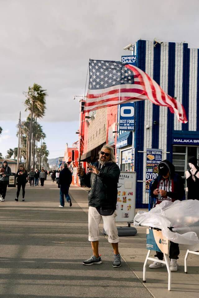 This old man loves America so much that he takes the American flag to Muscle Beach and sings