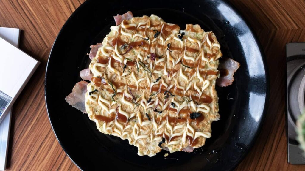 Homemade Okonomiyaki Japanese savory pancake topped with sauce and mayonnaise