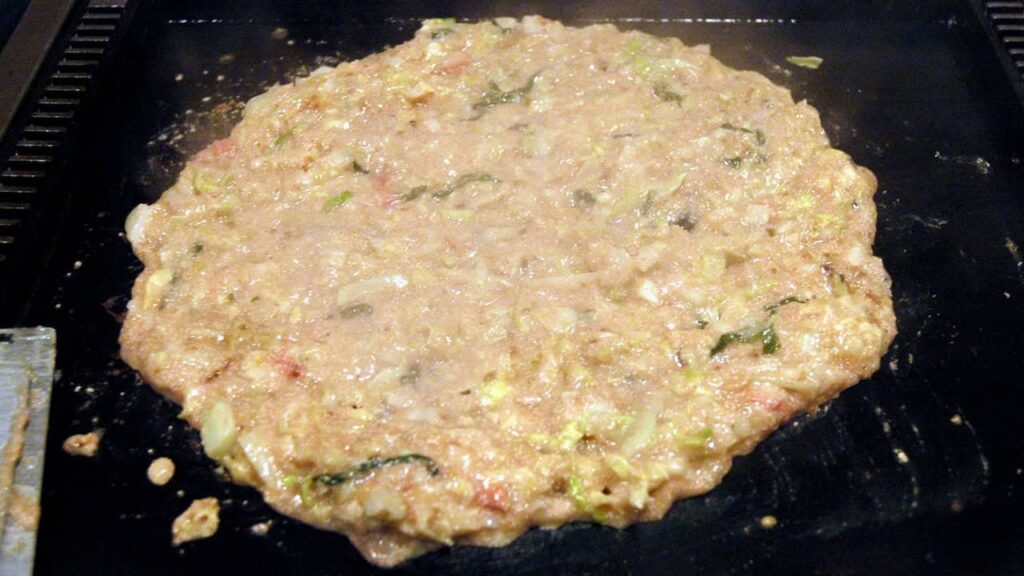 Monjayaki Japanese savory pancake cooking on a hot teppan griddle