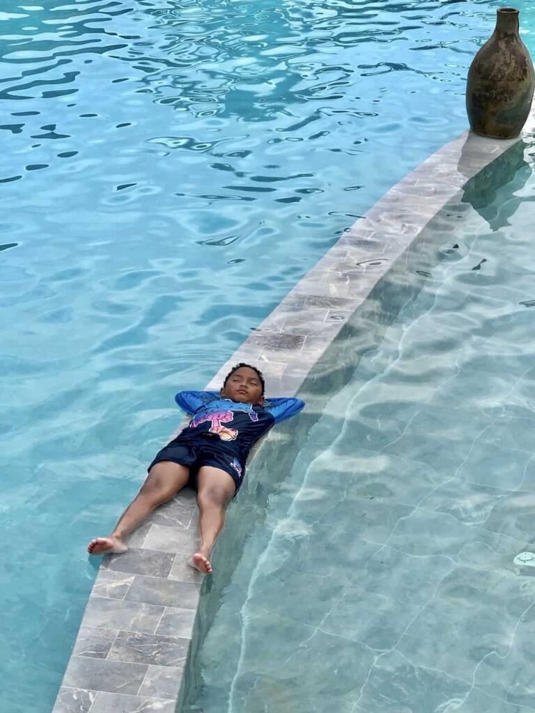 a boy is trying to sleep at the pool of Can Tho Ecolodge