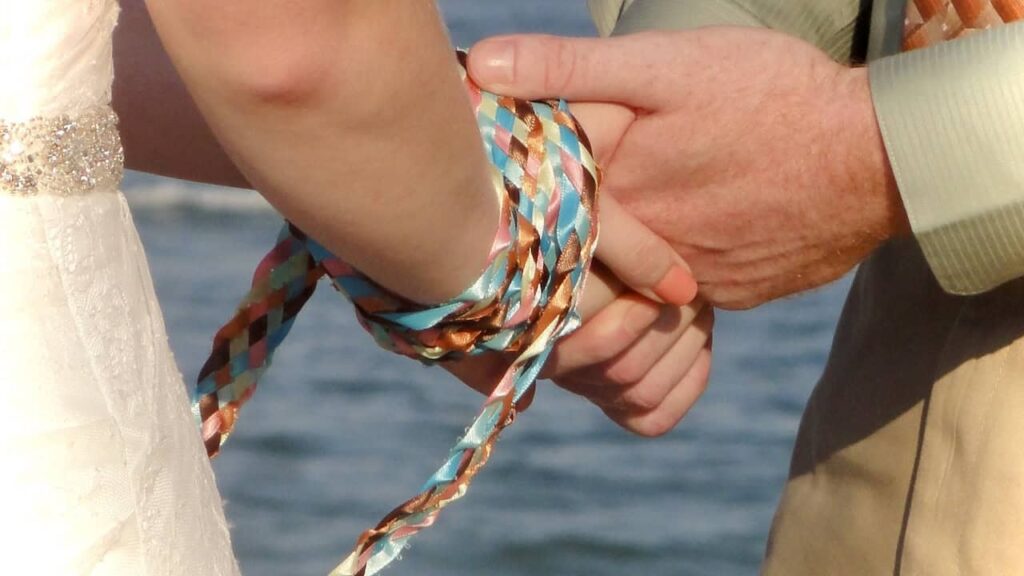 European handfasting wedding ritual with braided cord tying couple’s hands in cultural wedding traditions