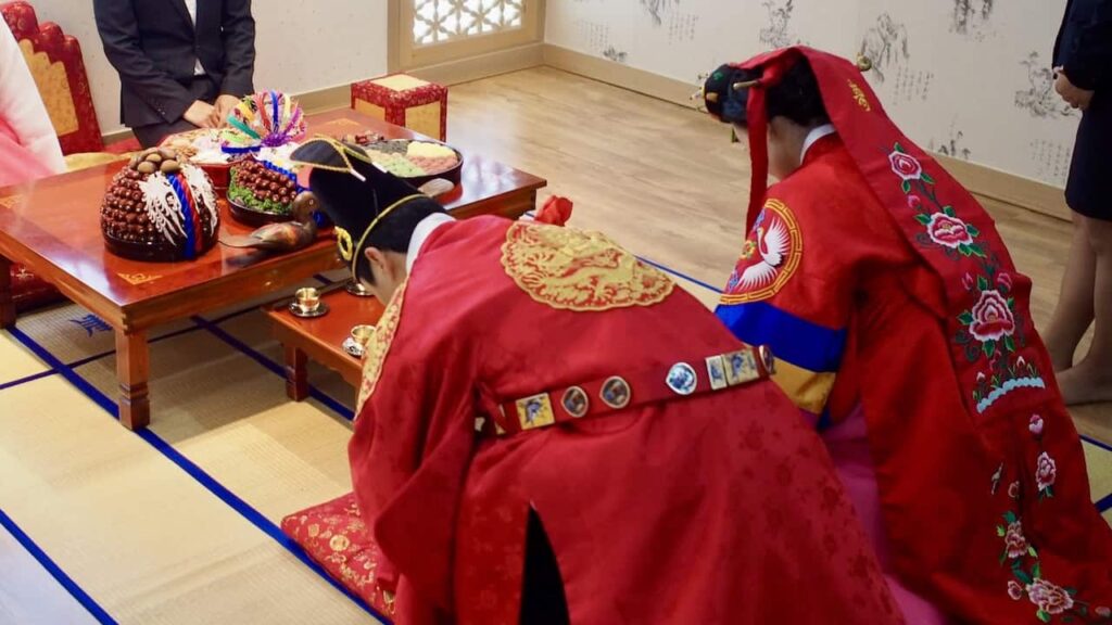 Korean paebaek wedding ceremony with couple bowing to elders in traditional attire cultural wedding traditions