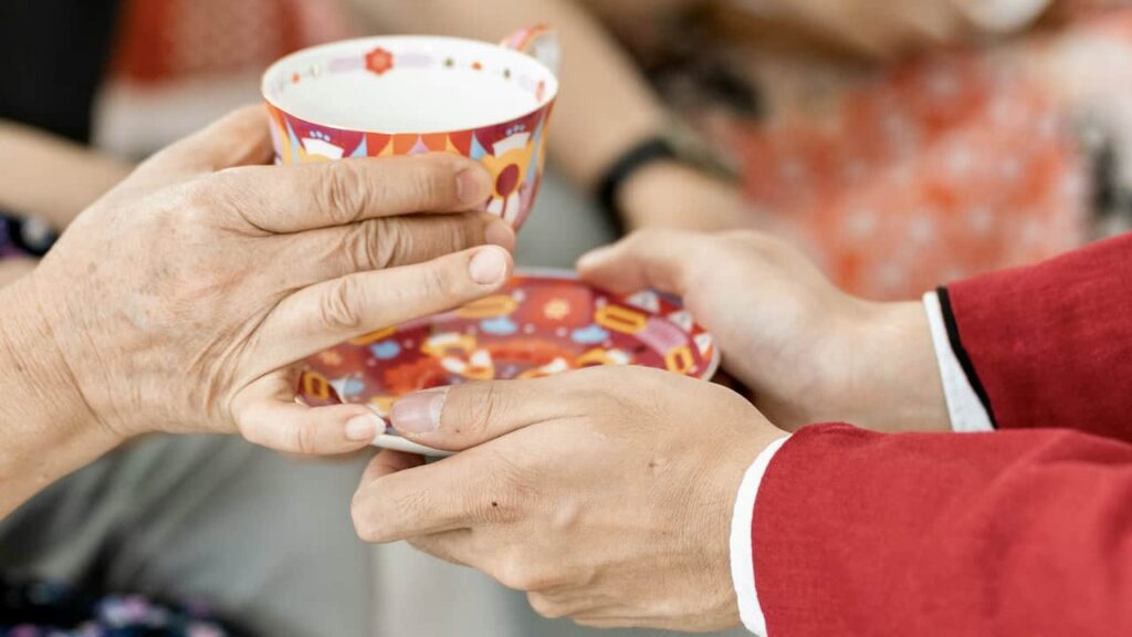 Chinese tea ceremony jing cha with couple serving tea to elders as part of cultural wedding traditions