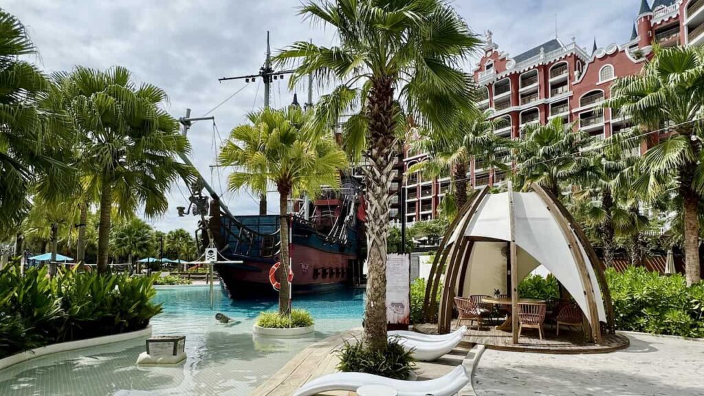 Pool cabana and pirate ship surrounded by palm trees