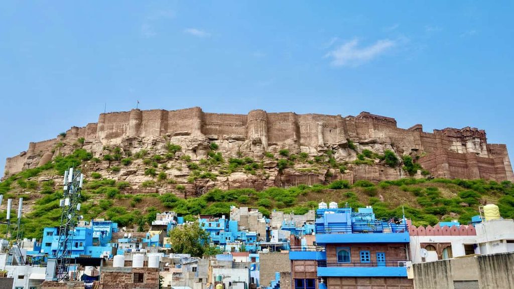 Mehrangarh Fort rising above the blue-painted houses of Jodhpur in luxury tour of India